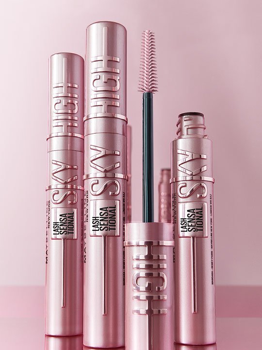 Mehrere Sky High Mascara Tuben in Roségold von Maybelline, mittig eine geöffnete Variante mit Bürste.