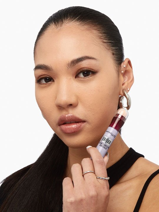 Frau mit Instant Anti-Age Löscher Color Correcting Concealer in Lila