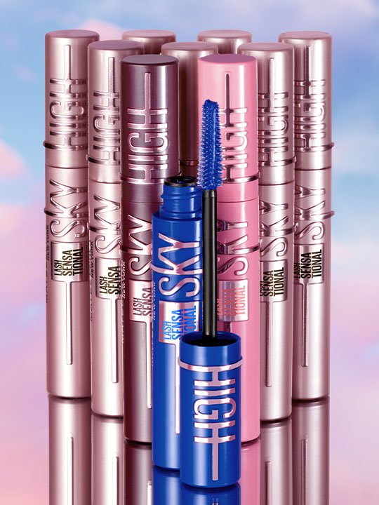 Mehrere Sky High Mascaras in verschiedenen Farben – im Fokus die geöffnete blaue Variante mit sichtbarer Bürste vor roséfarbenem Hintergrund.