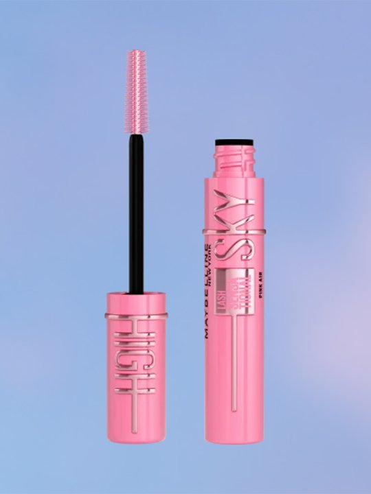 Geöffnete pinke Sky High Mascara mit passender roséfarbener Bürste vor blauem Hintergrund.