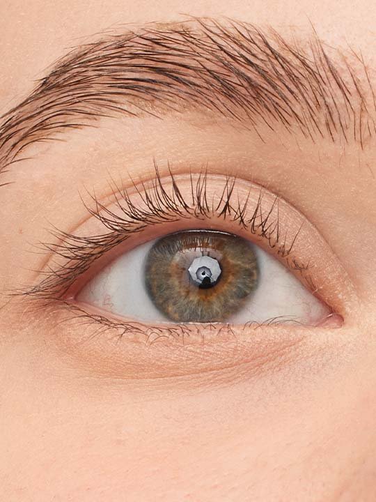 Ungeschminktes Auge mit deutlich sichtbarer zweifarbiger Iris und natürlicher Braue.