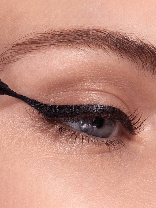 Bild eines Frauenauges mit nach oben gerichteten Augen und Eyeliner