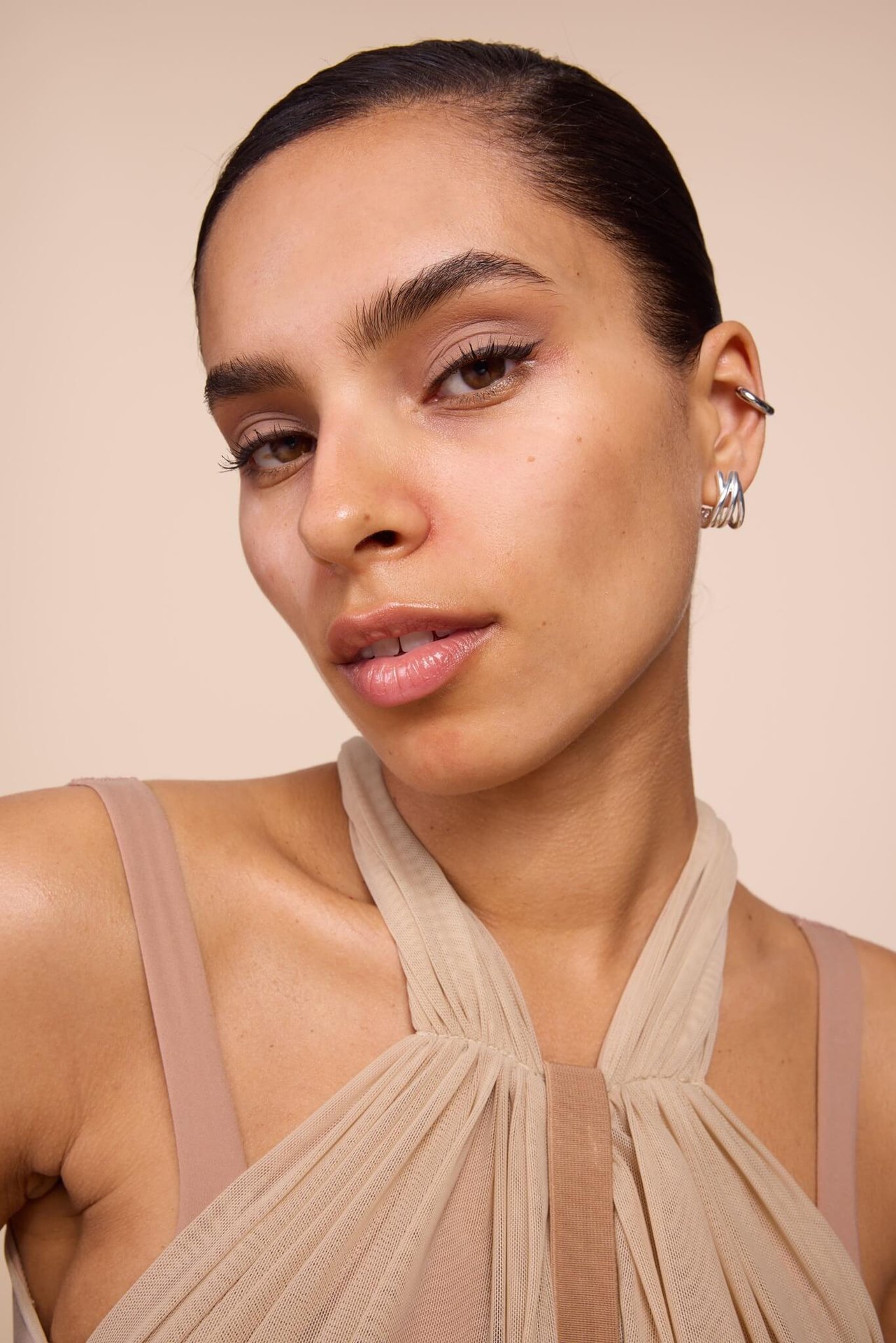 Junge Frau mit elegantem Make-up mit schwarzem Eyeliner, nude-rosa Lidschatten und glossy Lippen