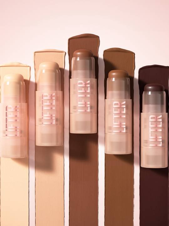 Fünf Lifter Stix von Maybelline New York in verschiedenen Farbtönen vor gezogenen Streifen aus Contouring-Creme