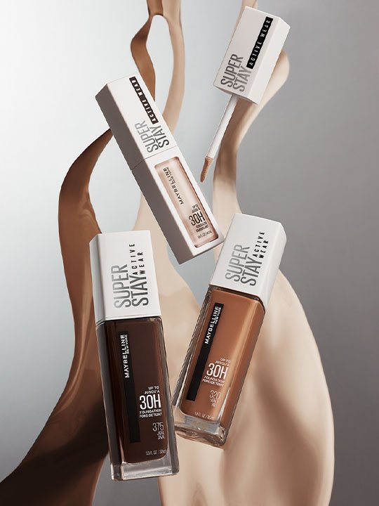 Maybelline Super Stay Foundation und Concealer schweben vor fließendem Make-up.