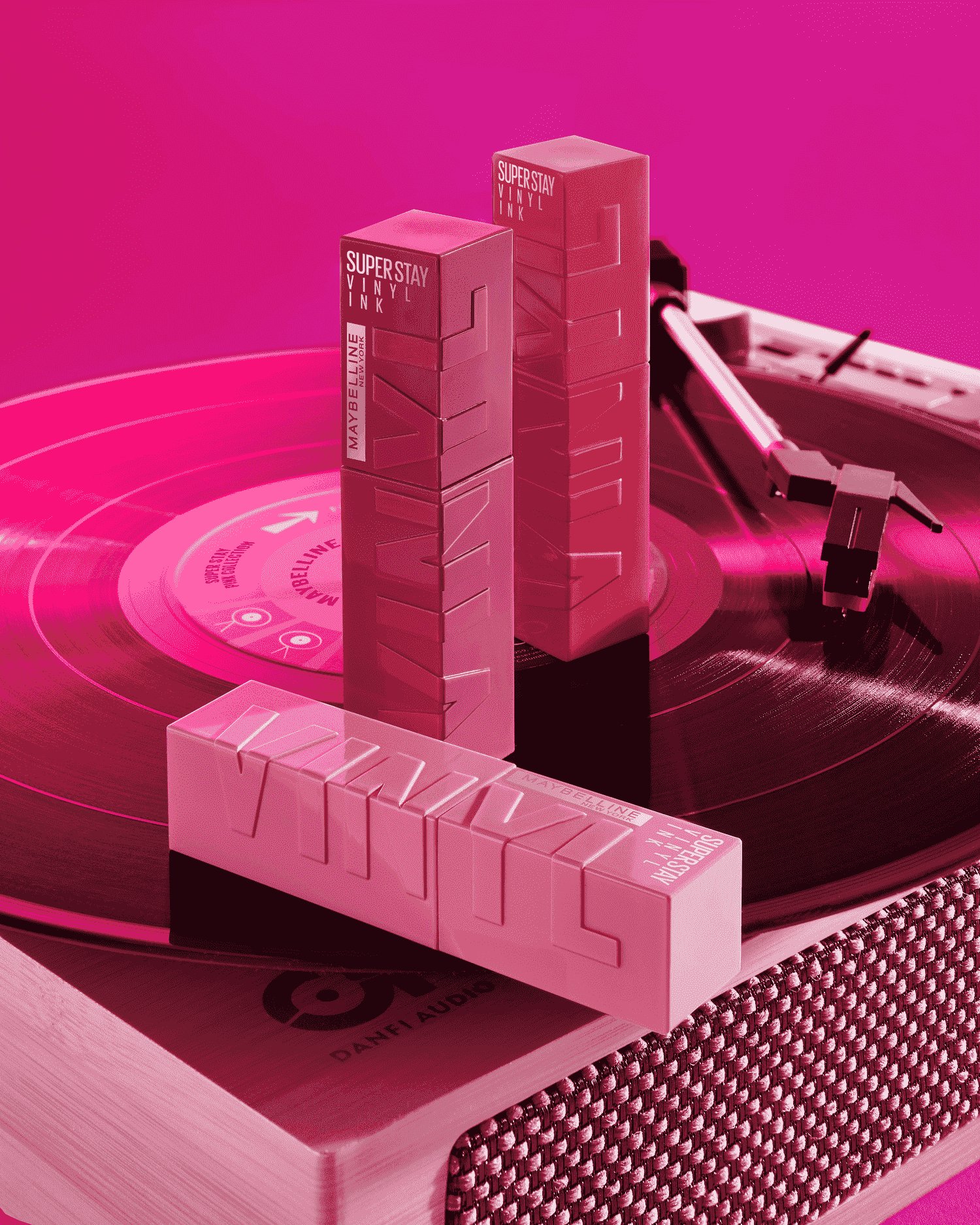 Drei Super Stay Vinyl Ink Lippenstifte von Maybelline New York auf einem Plattenspieler in pinkem Licht