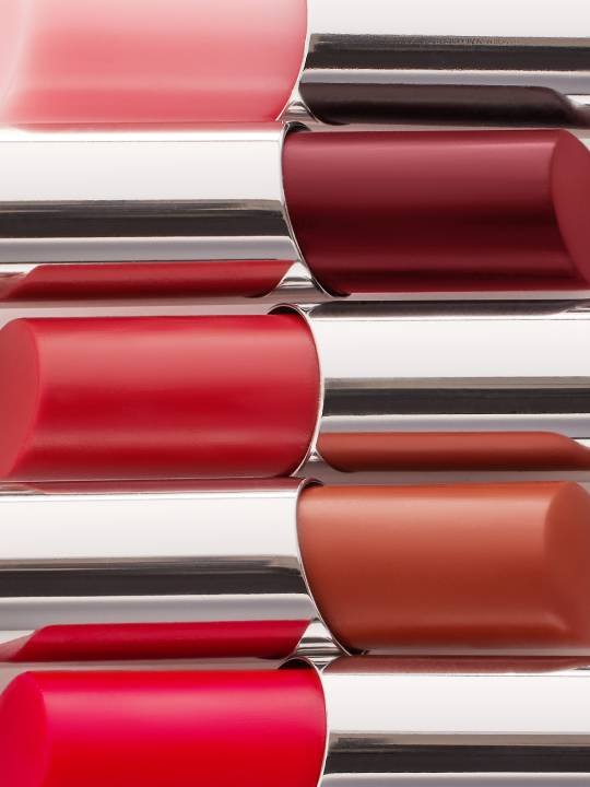 Fünf Lippenstifte in verschiedenen Rottönen übereinander