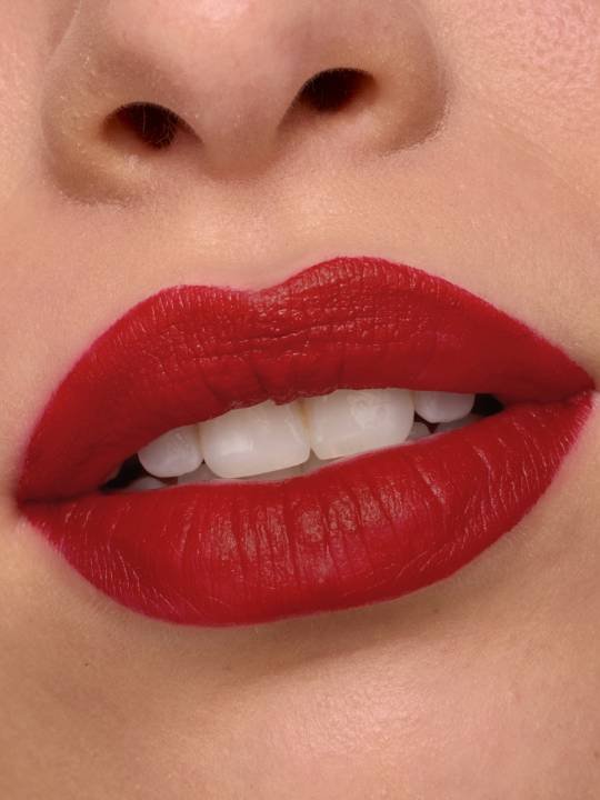 Nahaufnahme eines Mundes mit leicht geöffneten Lippen geschminkt mit rotem Lippenstift mit Satin-Finish