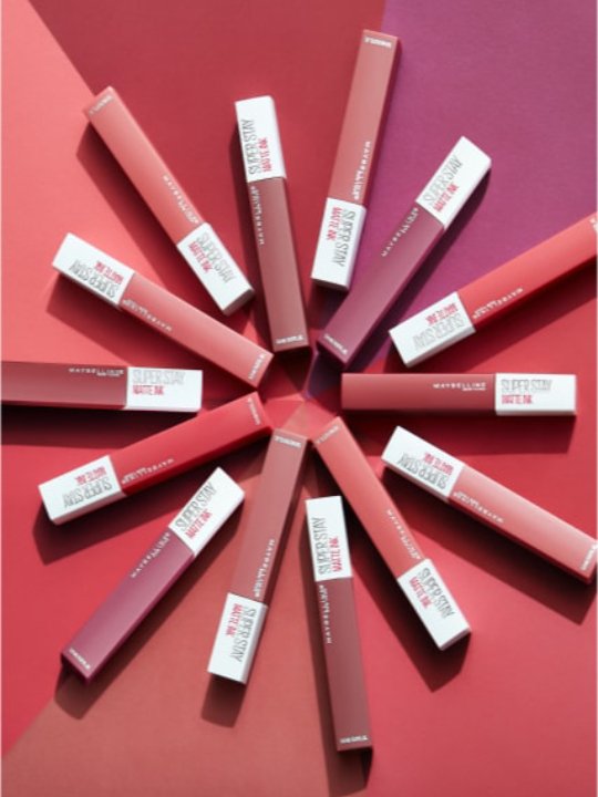 14 Farbtöne des Super Stay Matte Ink Lippenstifte von Maybelline New York positioniert in Sonnenform