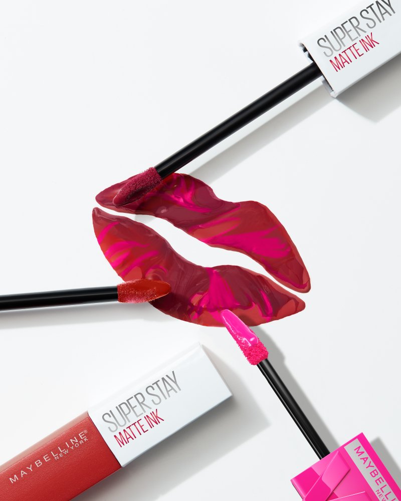 Zeichnung eines roten Kussmunds und drei Applikatoren der Super Stay Matte Ink Lippenstifte von Maybelline New York