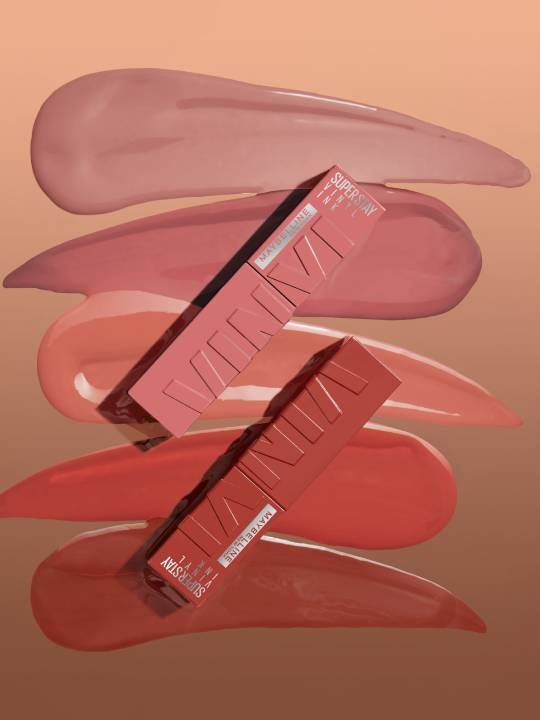 Ein Nudefarbener und ein brauner Super Stay Vinyl Ink Lippenstift vor einem orangebraunen Hintergrrund