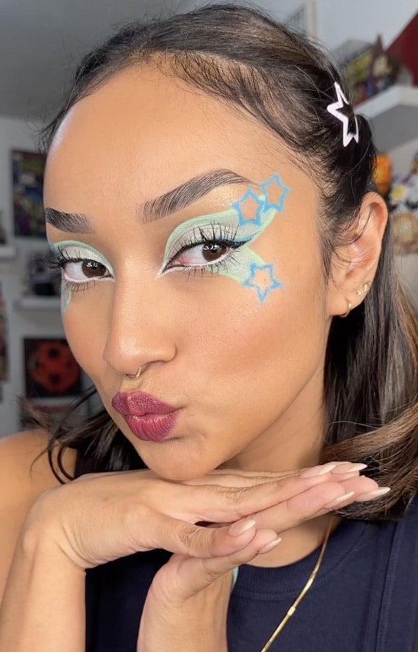 Eine Frau mit blauen und grünen Augen Make-Up.
