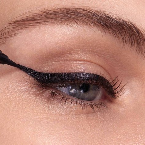Auge einer Frau, bei der der Lidstrich mit dem Wing vollendet wird