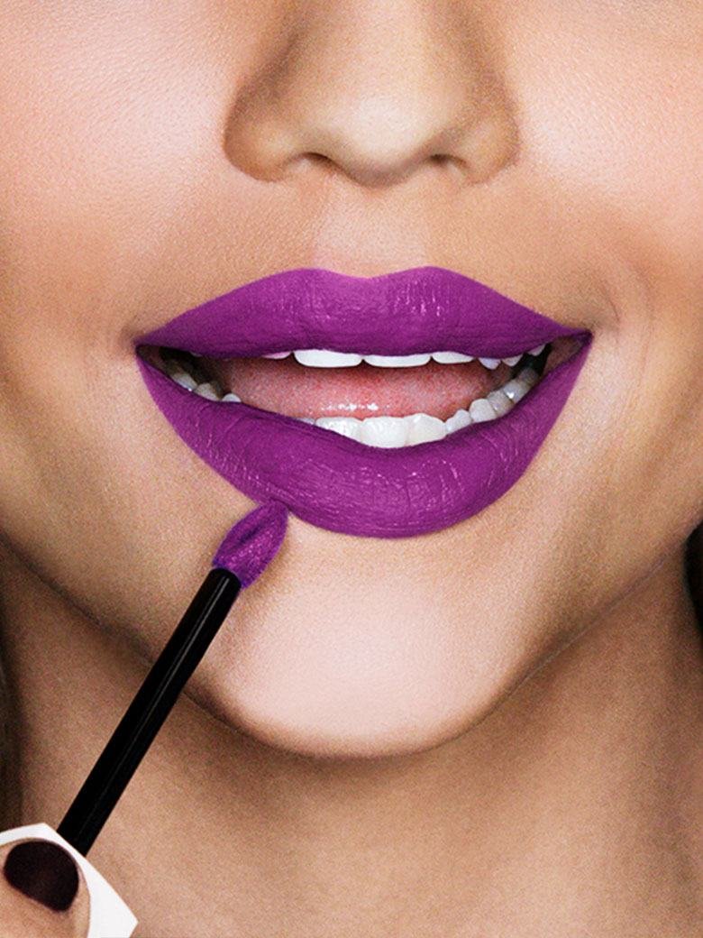 „Frau, die mit dem Applikator eines Liquid Lipsticks die Konturen ihrer Lippen umrandet