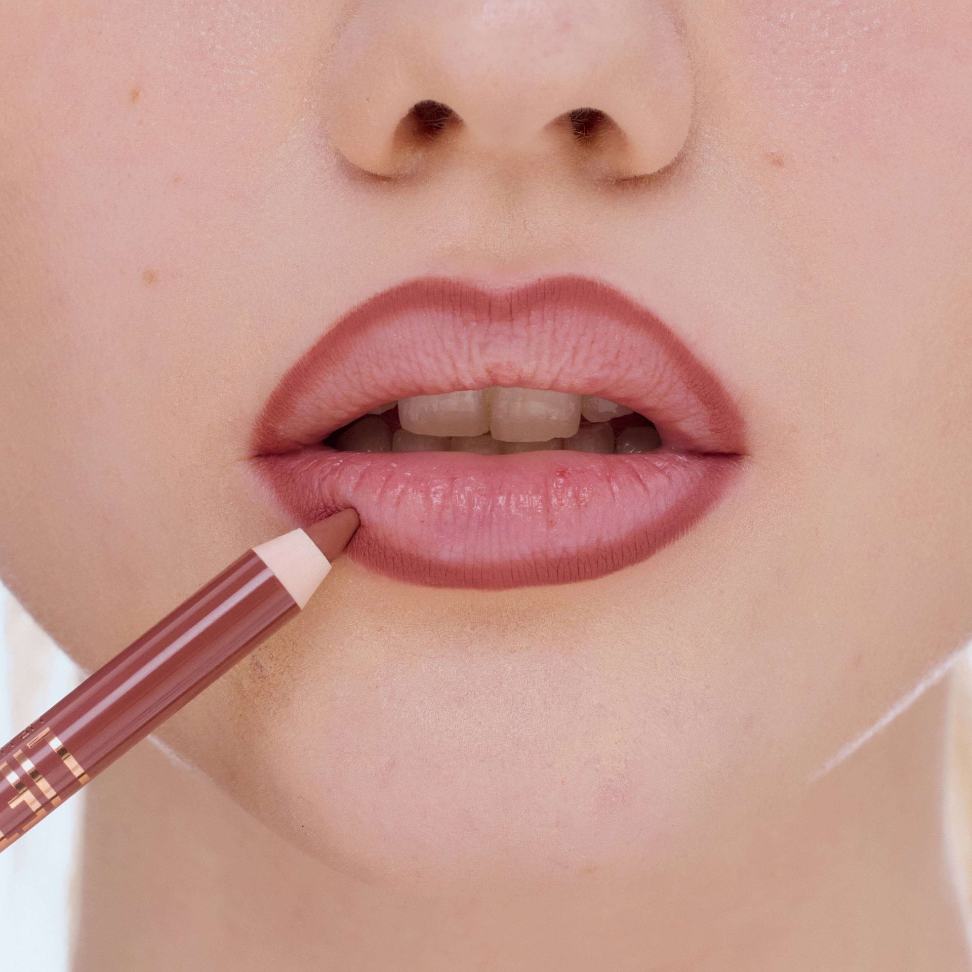 Mund einer Frau, die ihre Lippen mit einem Lipliner umrandet