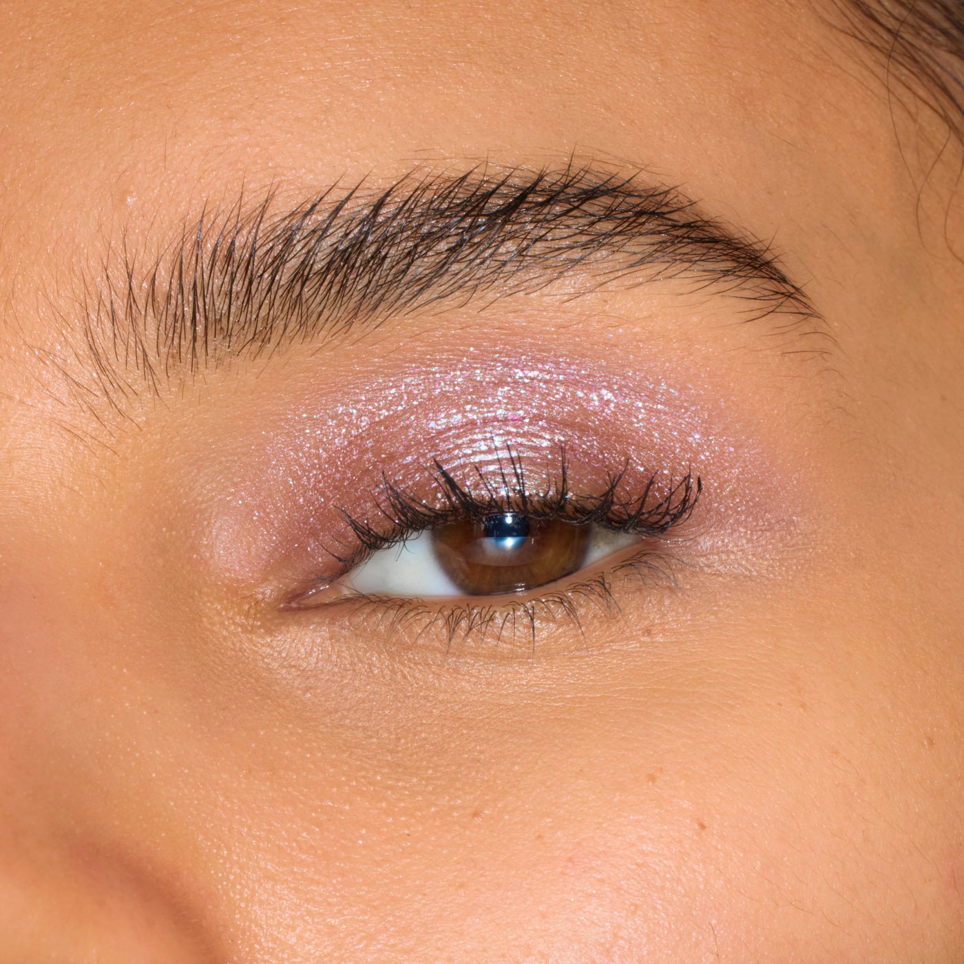 Nahaufnahme eines Auges mit rosa Glitzerlidschatten