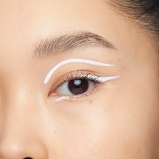 Nahaufnahme eines Auges mit weißem Eyeliner entlang des oberen und unteren Wimpernkranzes sowie entlang der Lidfalte