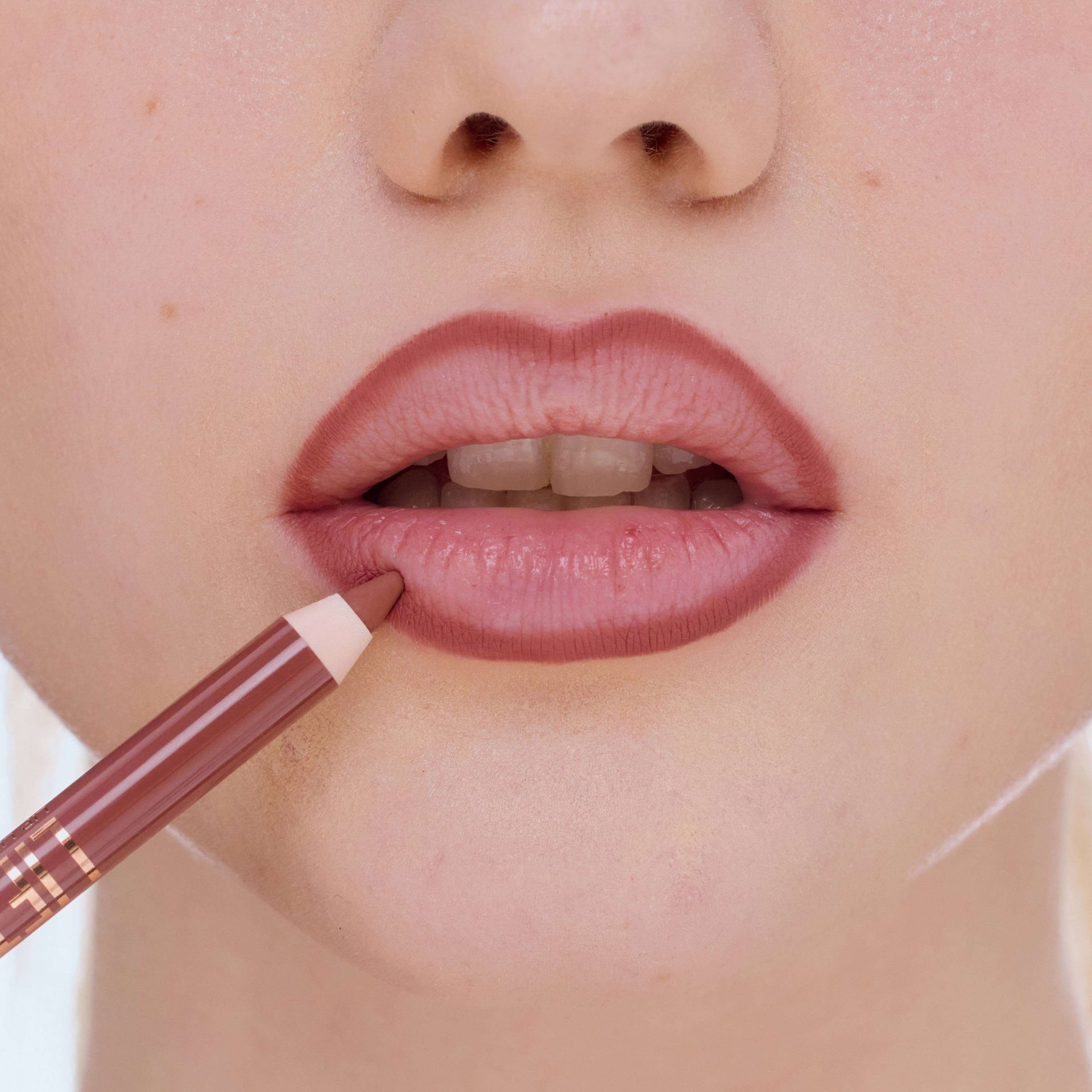 Mund einer Frau, die ihre Lippen mit einem Lipliner umrandet